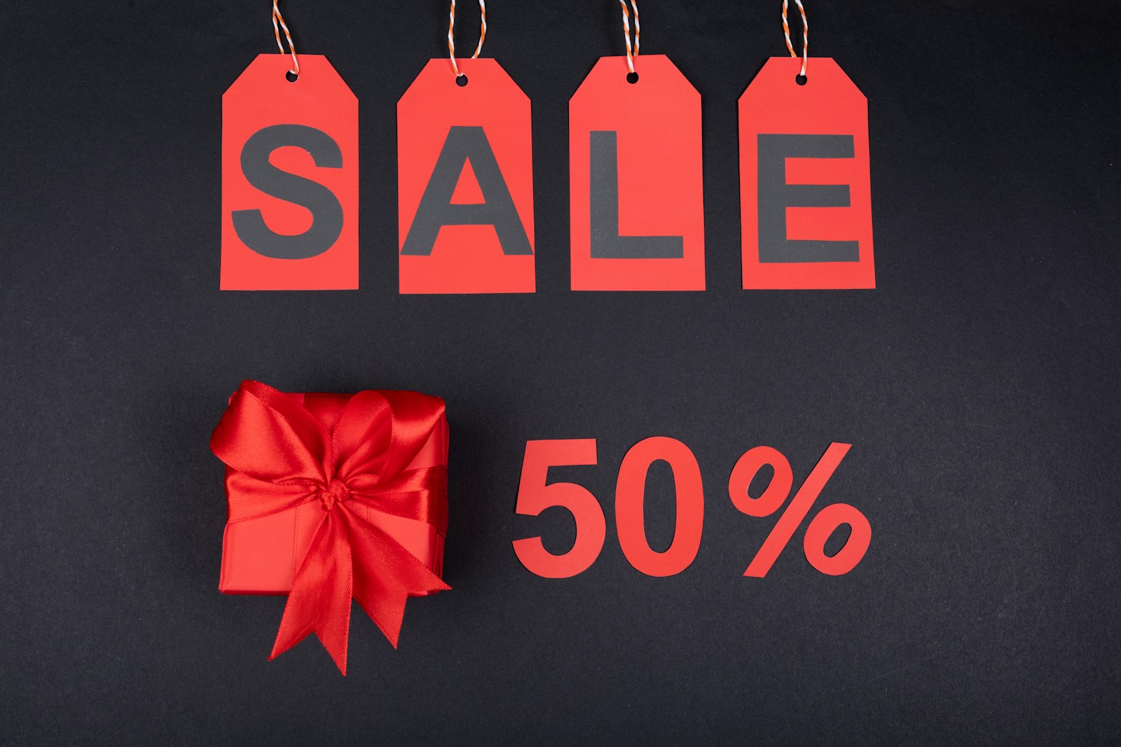 A red SALE tag with a gift box and a 50% discount label