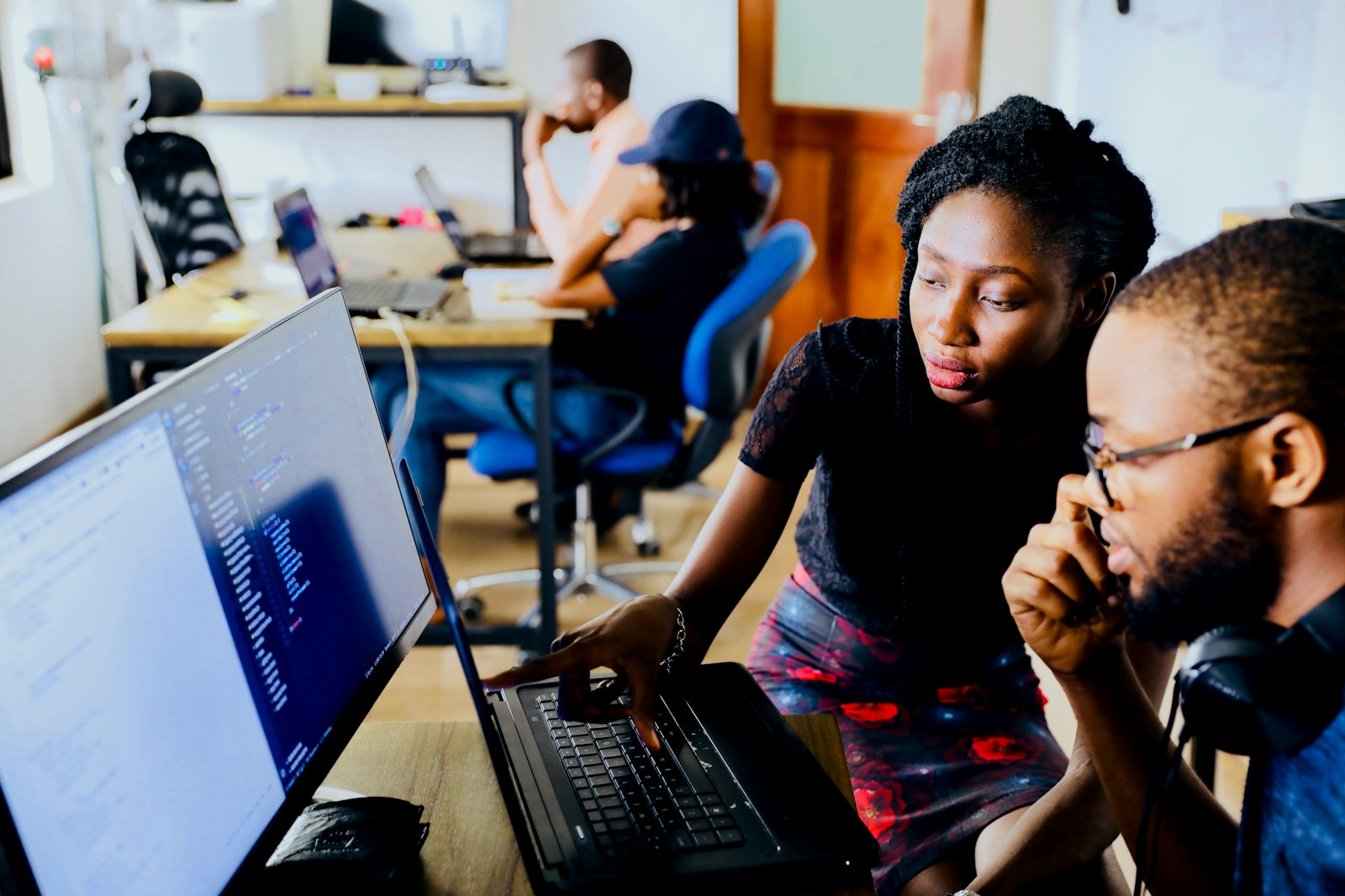 Two developers reviewing code together on a laptop